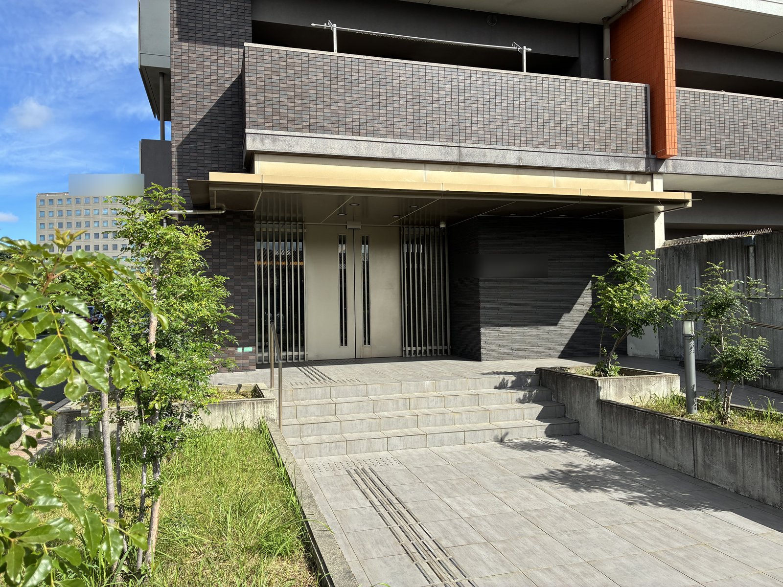 植栽と階段のあるマンションのエントランス